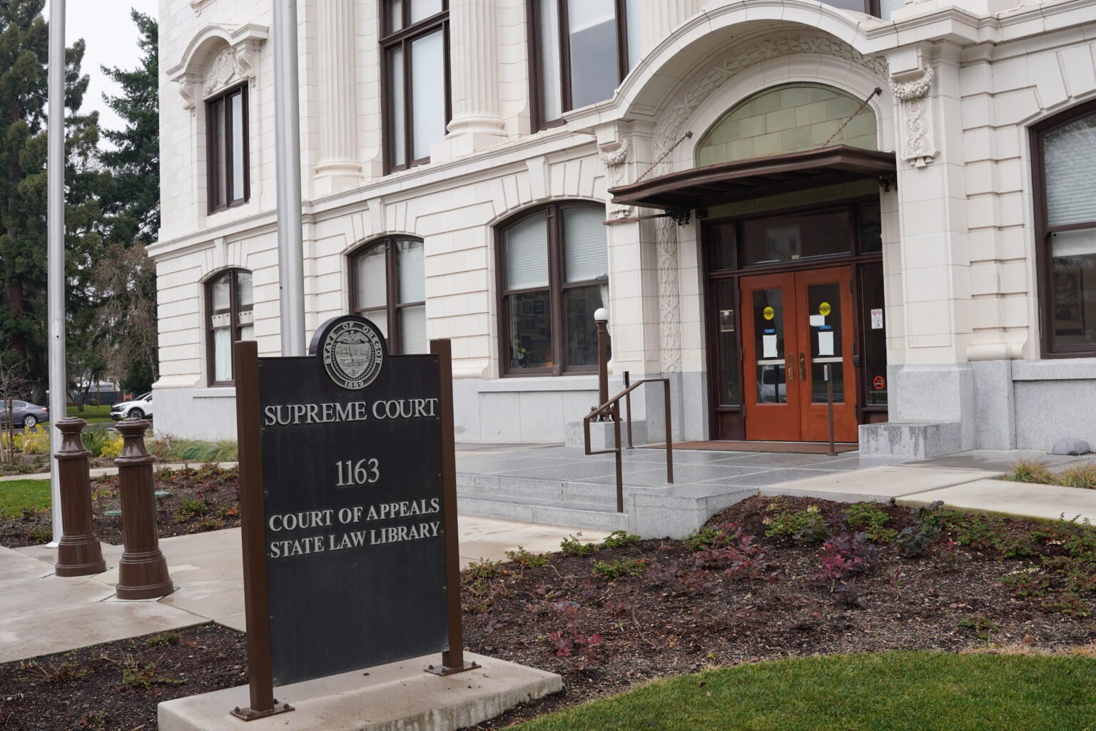 A state supreme court and court of appeals building with a sign reading Supreme Court, Court of Appeals, State Law Library.