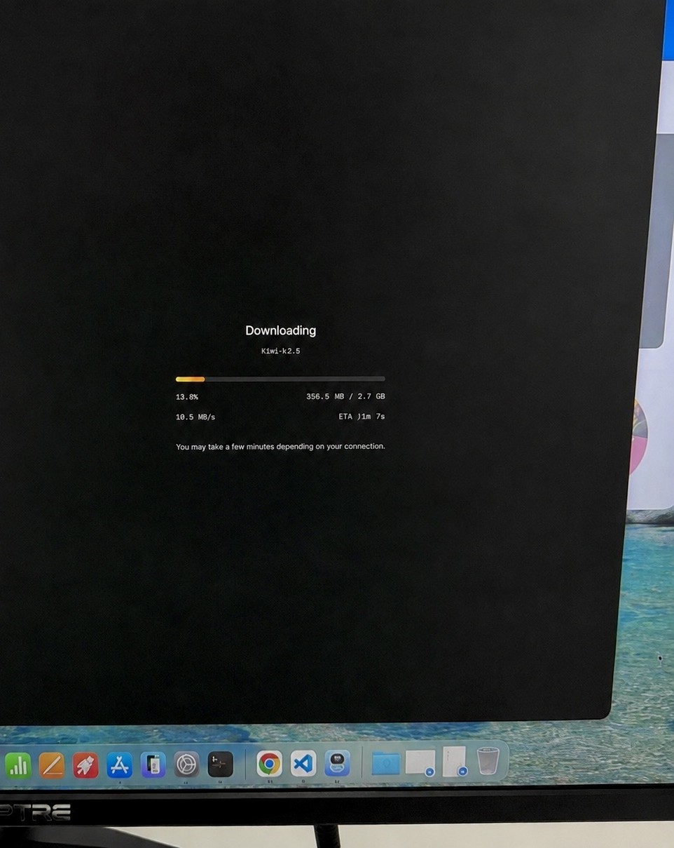 A monitor showing the Kimi K2.5 open weight model downloading to a Mac Studio for fully local use